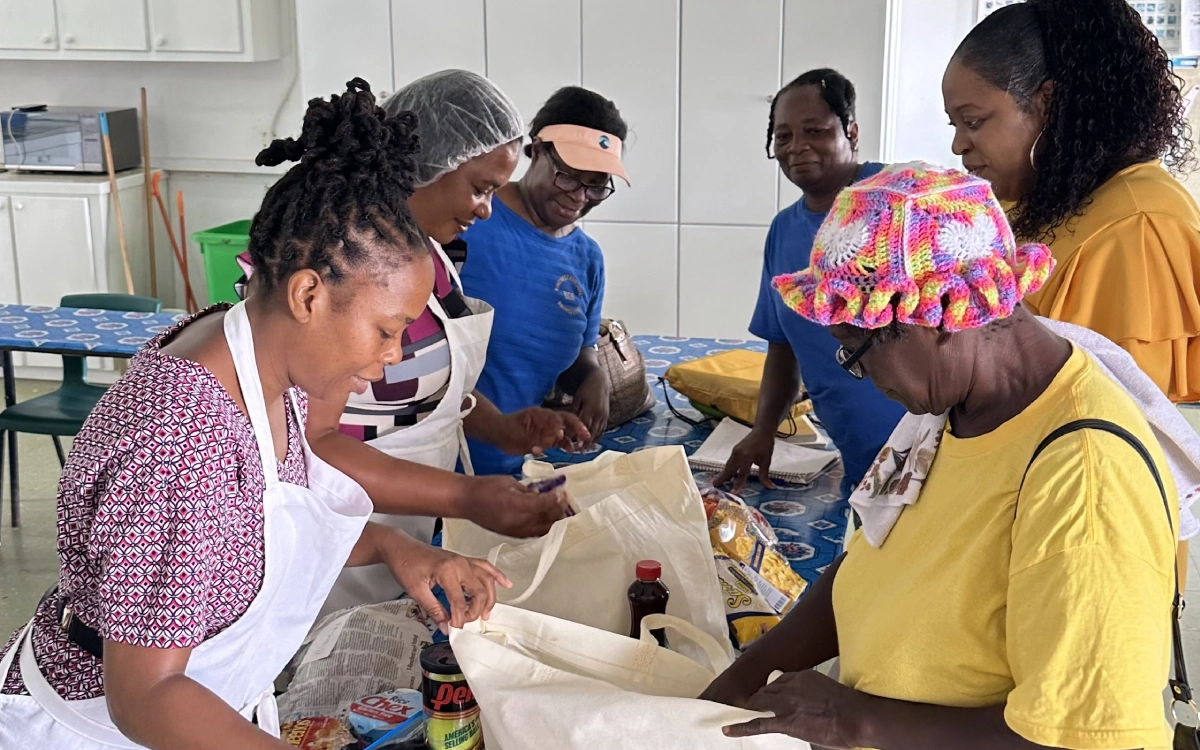 A group of people in the kitchen preparing food.