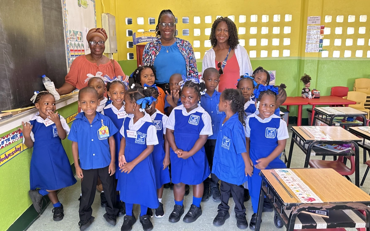 A group of children standing in front of a teacher.