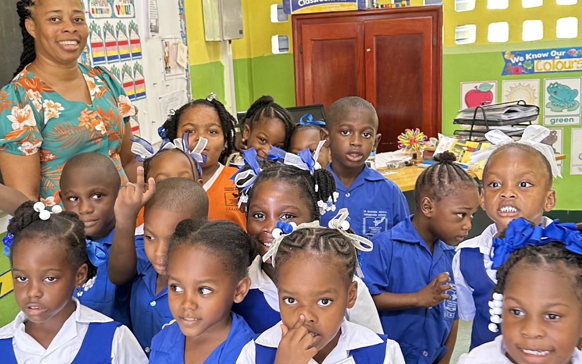 A group of children in blue shirts and white shirts.