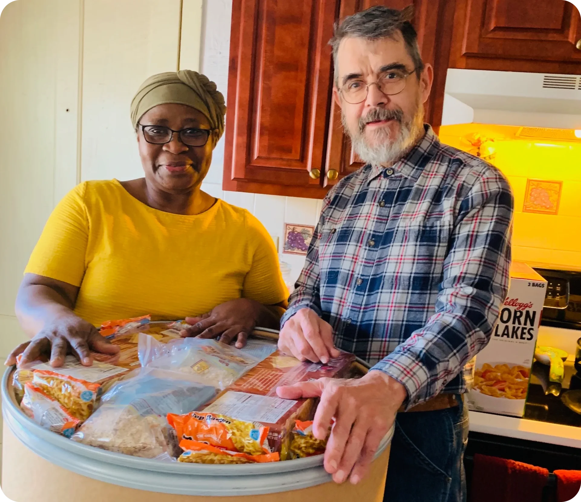 A man and woman are preparing food in the kitchen.